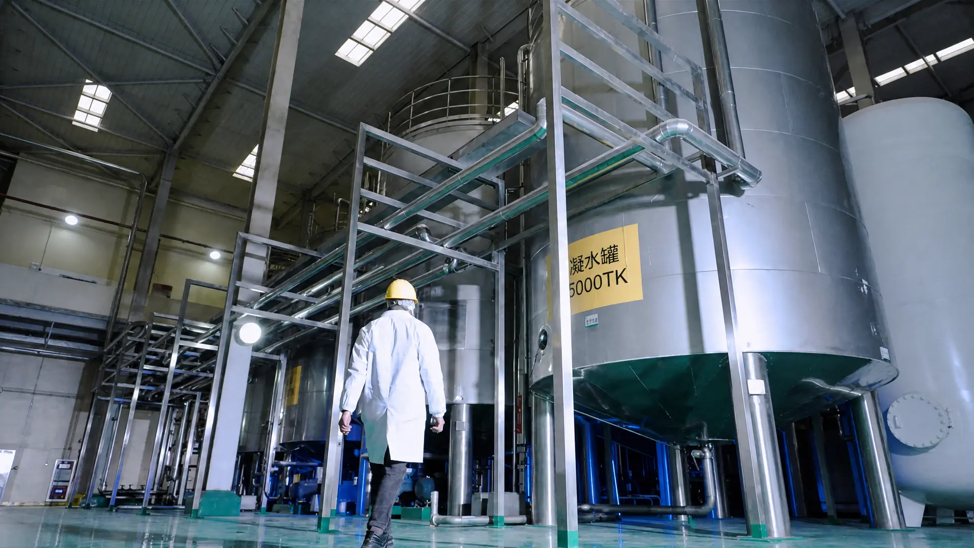 worker inspecting storage tanks in modified starch processing facility
